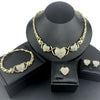 A gold heart crystal jewelry set featuring a necklace and earrings displayed on a black stand.