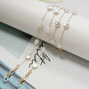Collares de perlas y cuentas tono dorado con adornos de vidrio transparente, mostrados sobre fondo blanco.