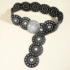 A black denim belt featuring various circular studs and a decorative silver medallion.