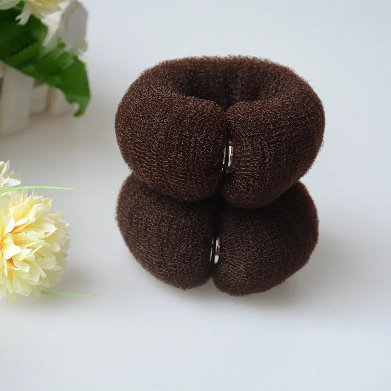 A stack of dark brown, textured gauze hair buns or hair ties.