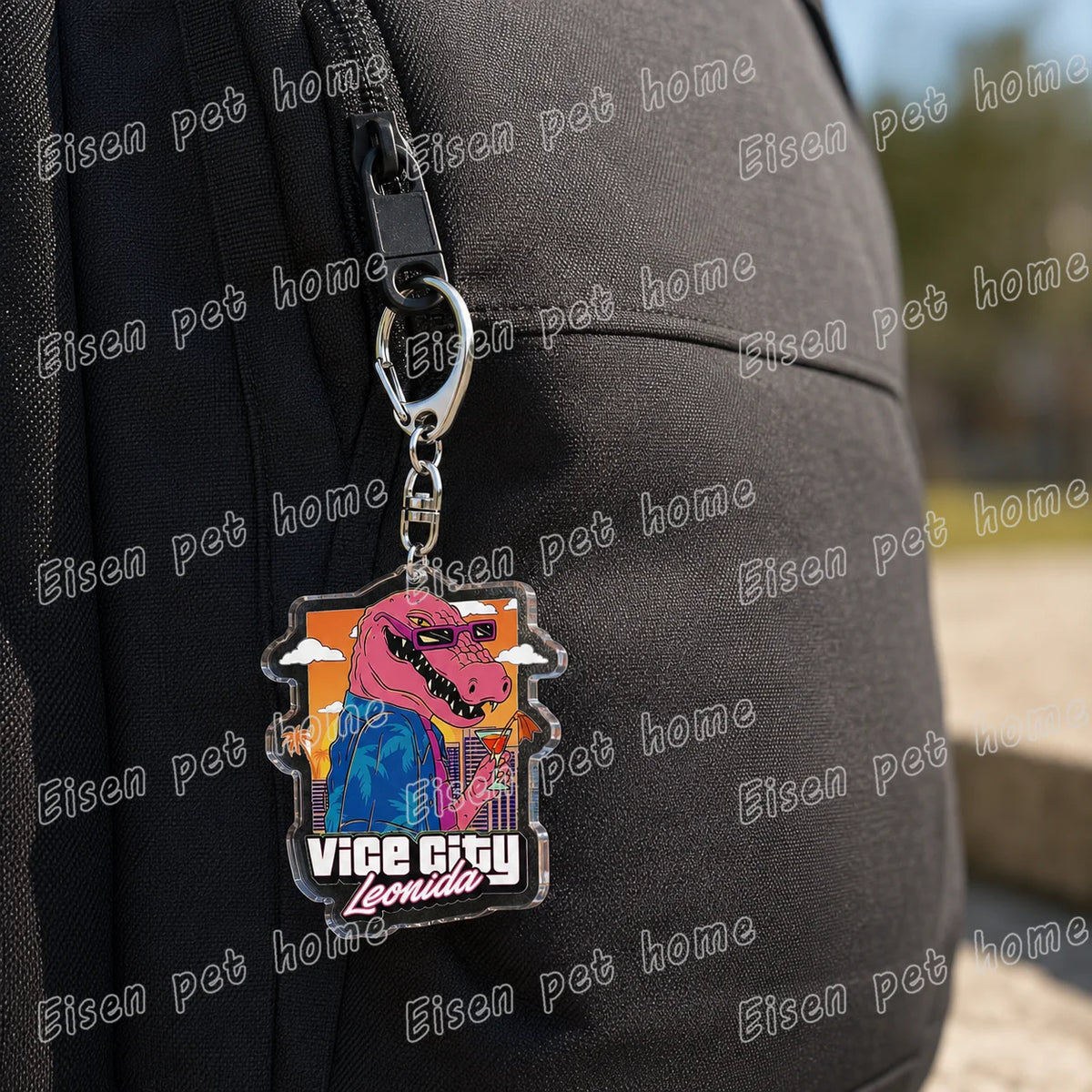 A silver keychain featuring a pink dinosaur character from Vice City on a black strap.
