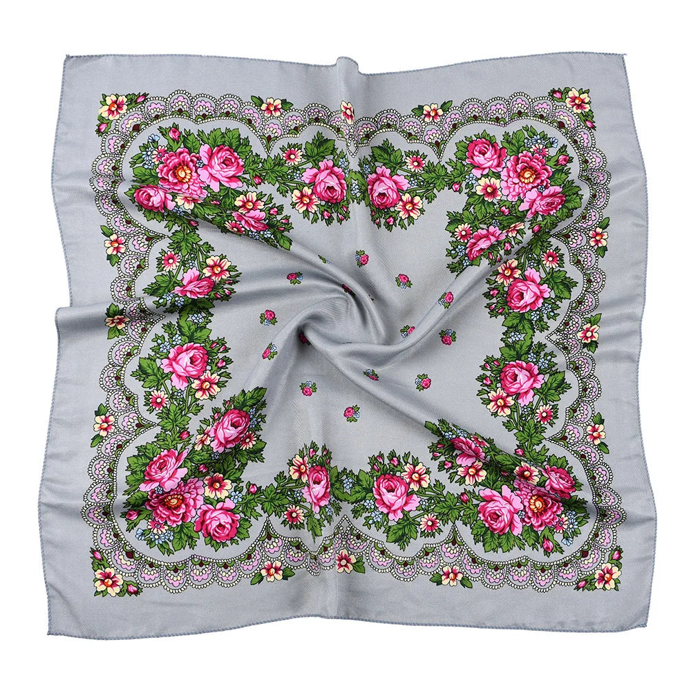 A gray scarf featuring a detailed floral print with pink and green roses and foliage.