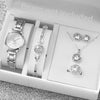 A white box contains an elegant quartz wrist watch, a diamond pendant necklace, and a ring set.