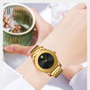 A gold-toned minimalist quartz wristwatch is shown on a wrist next to a textured green cup.