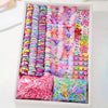 A box filled with colorful decorative hair accessories including scrunchies and ties in various shades of pink, purple, blue,