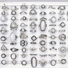 A collection of silver and gold charm rings featuring natural stones, including various designs and textures.