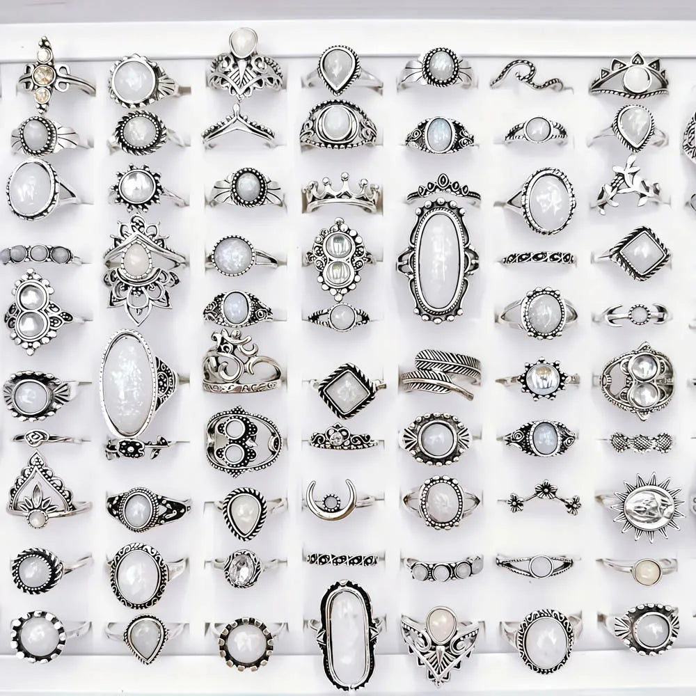 A collection of silver and gold charm rings featuring natural stones, including various designs and textures.