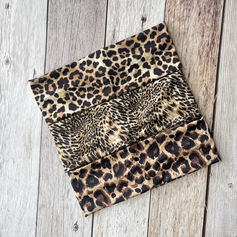 Un juego de tres bandas para la cabeza de deporte resistentes al agua con estampado de leopardo, sobre una superficie de made