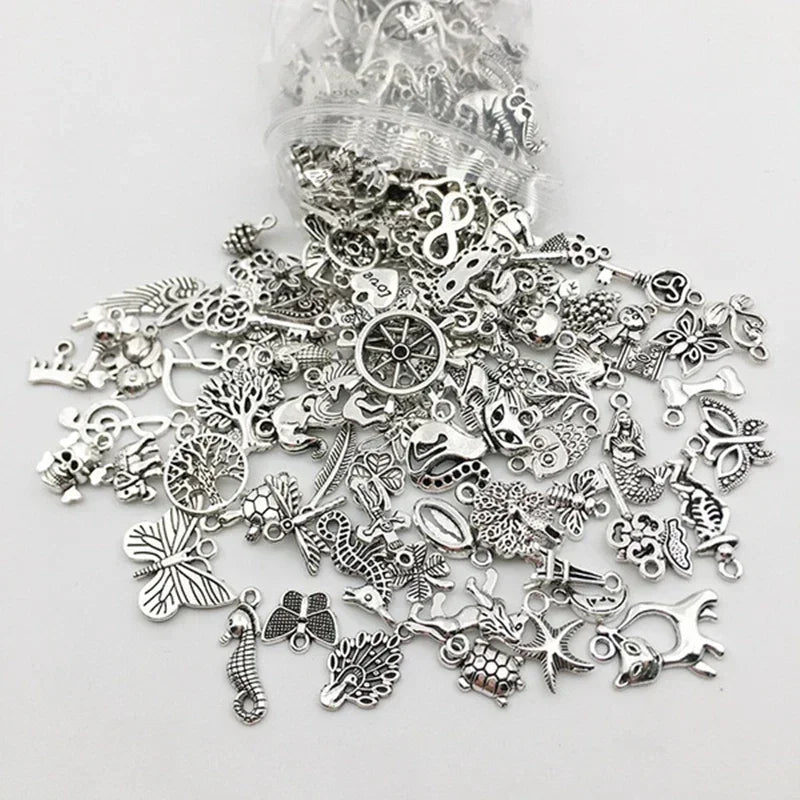 Eine Sammlung silberner tibetischer Anhänger und Perlen für DIY-Schmuckherstellung.