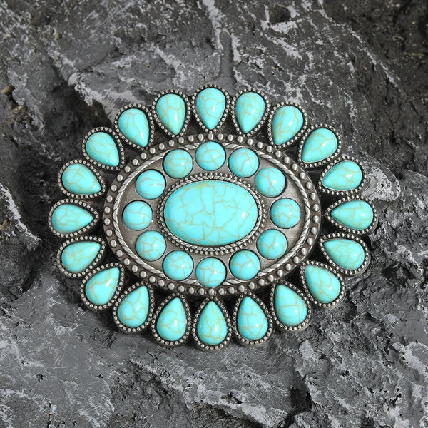 A silver beaded belt buckle featuring numerous light blue turquoise stones arranged in a floral pattern.