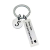 Silver keychain with a circular charm featuring a stylized letter S and a tag that reads Drive Safe I need you here with me