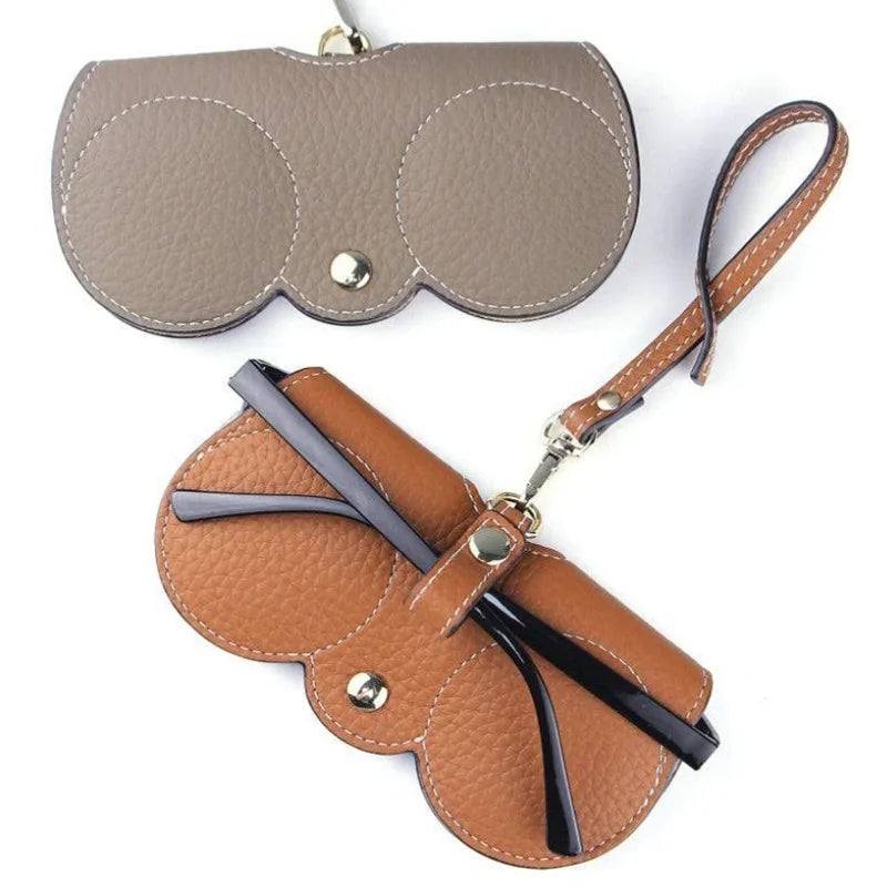 A brown leather pouch with a flap and strap for portable eyewear storage.