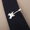 Silber-Titan-Klammer in Gitarrenform, geklemmt auf eine dunkelblaue Stoffkrawatte.