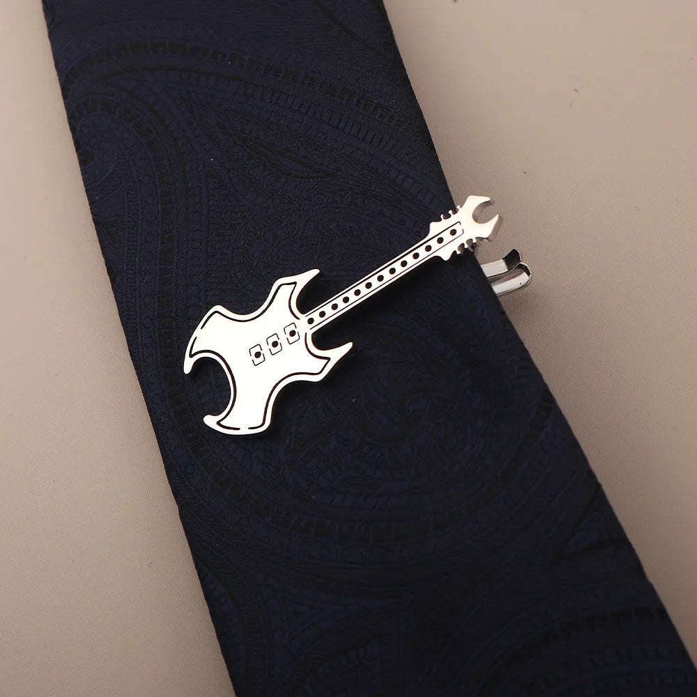 Silber-Titan-Klammer in Gitarrenform, geklemmt auf eine dunkelblaue Stoffkrawatte.