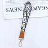 Brauner Leder-Handy-Lanyard mit gemustertem Stoffriemen und Metallverschluss
