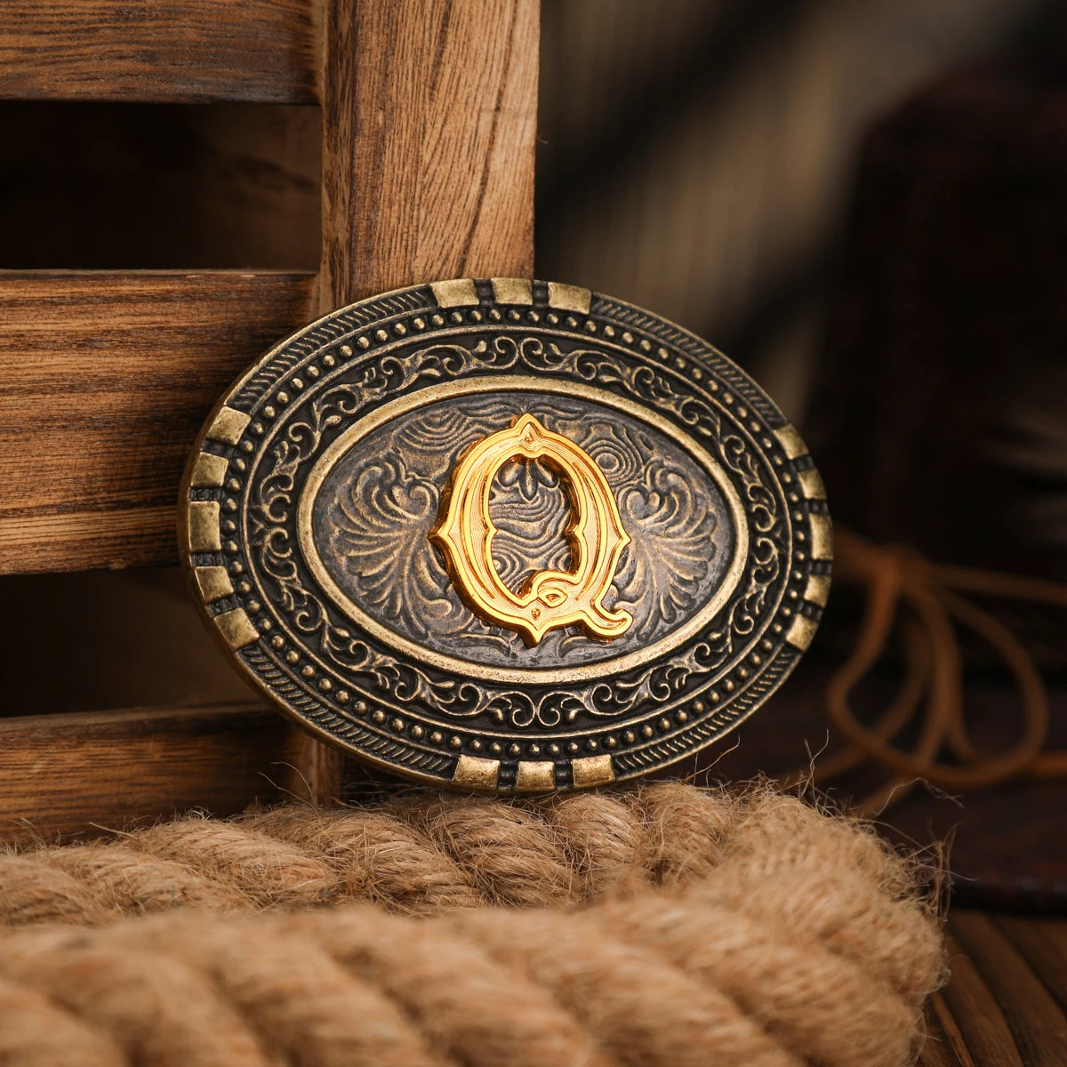 A vintage western belt buckle with an ornate gold design resting on a wooden surface.