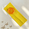 A yellow polka dot button headband with silver star embellishments lying on a light surface.
