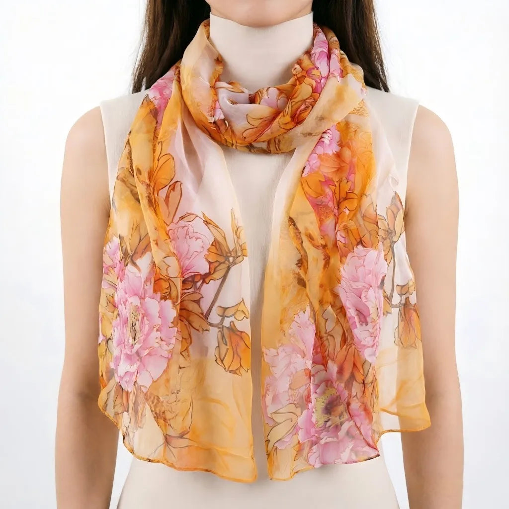 Une femme portant un élégant châle de soie floral aux tons orange et rose