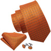 A set of three orange silk jacquard ties and a pair of silver tie clips.