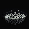 Tiara y corona de princesa de cristal brillante para el cabello, exhibidas sobre una superficie reflectante.
