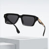 Schwarze retro quadratische Metall-Sonnenbrille mit goldenen Akzenten auf weißem Untergrund.