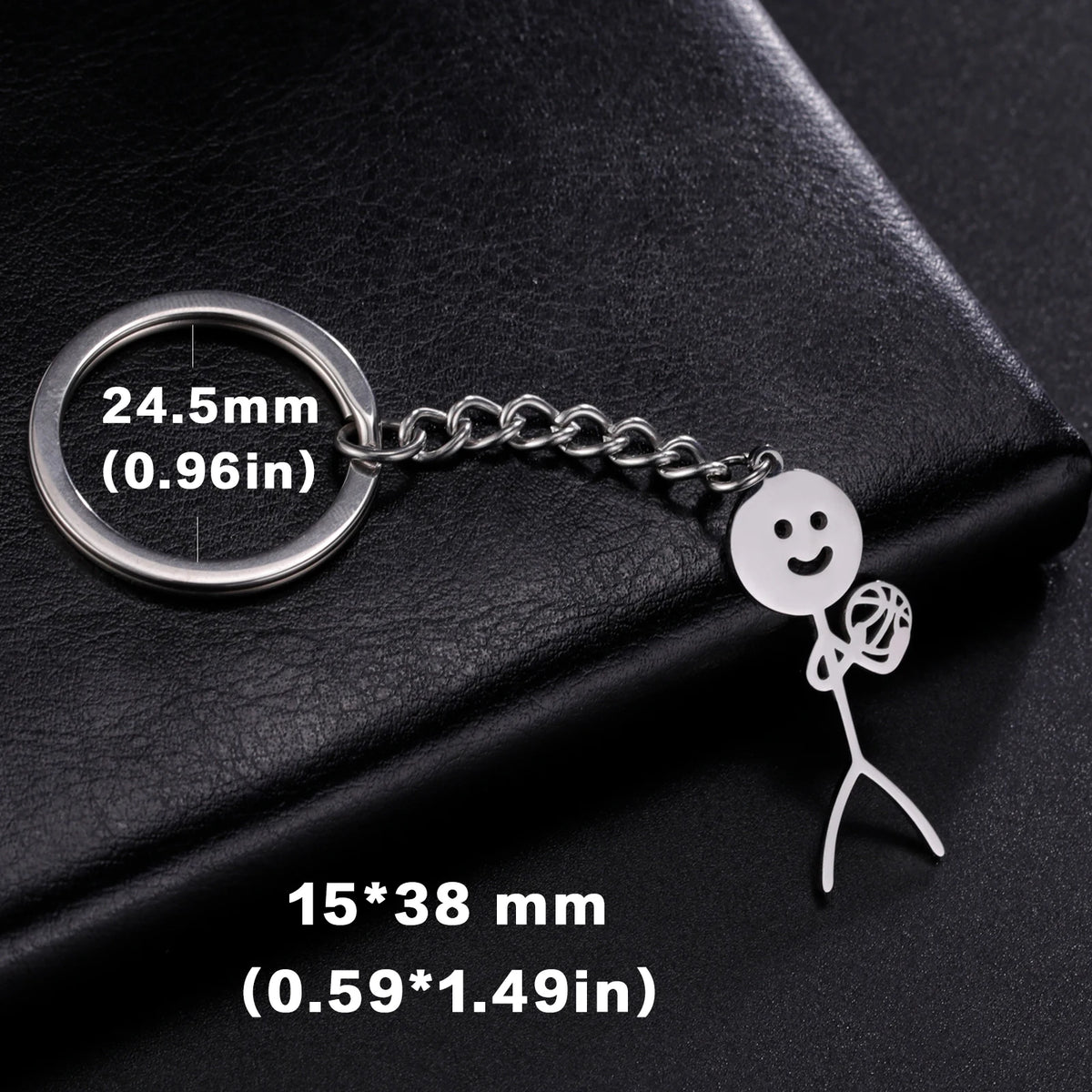 Silver keychain featuring a smiley face stickman and a circular tag.