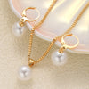 A set of dainty gold pearl jewelry featuring matching earrings and a delicate necklace displayed on a light surface.