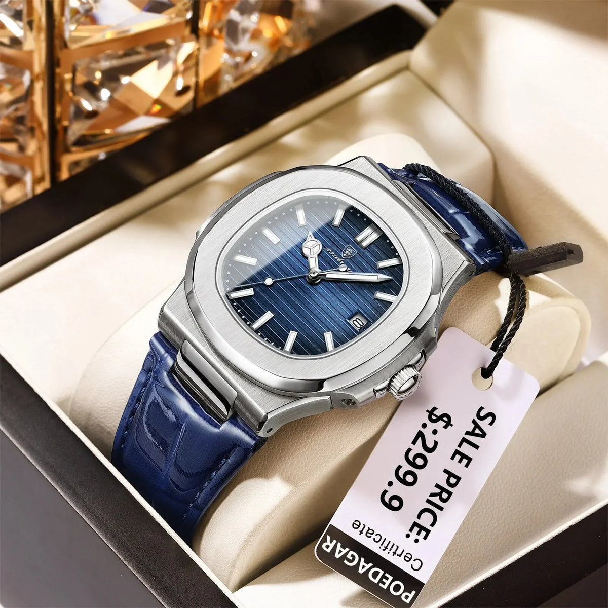 A silver-cased watch with a blue leather strap is displayed in a box.