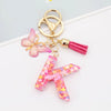 Alphabet letter acrylic keychain shaped like the letter T with pink butterfly and pink tassel