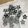 A collection of black and gray Y2K sweet star barrette hair clips scattered on white paper.