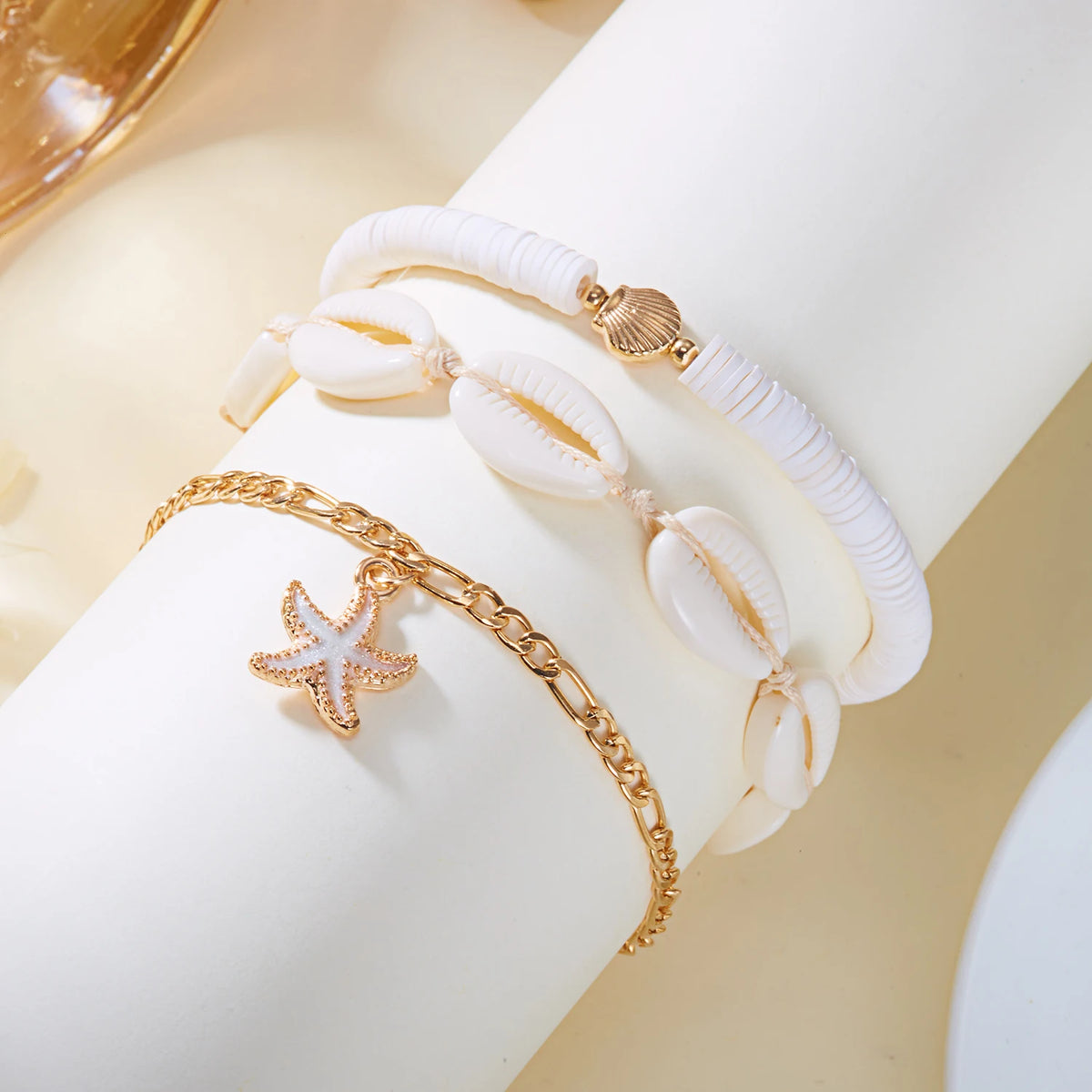 Gold beaded starfish conch anklet bracelet on a white wrist.