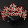 Tiare et couronne en strass de cristal rouge et transparent, présentés sur une boîte noire.