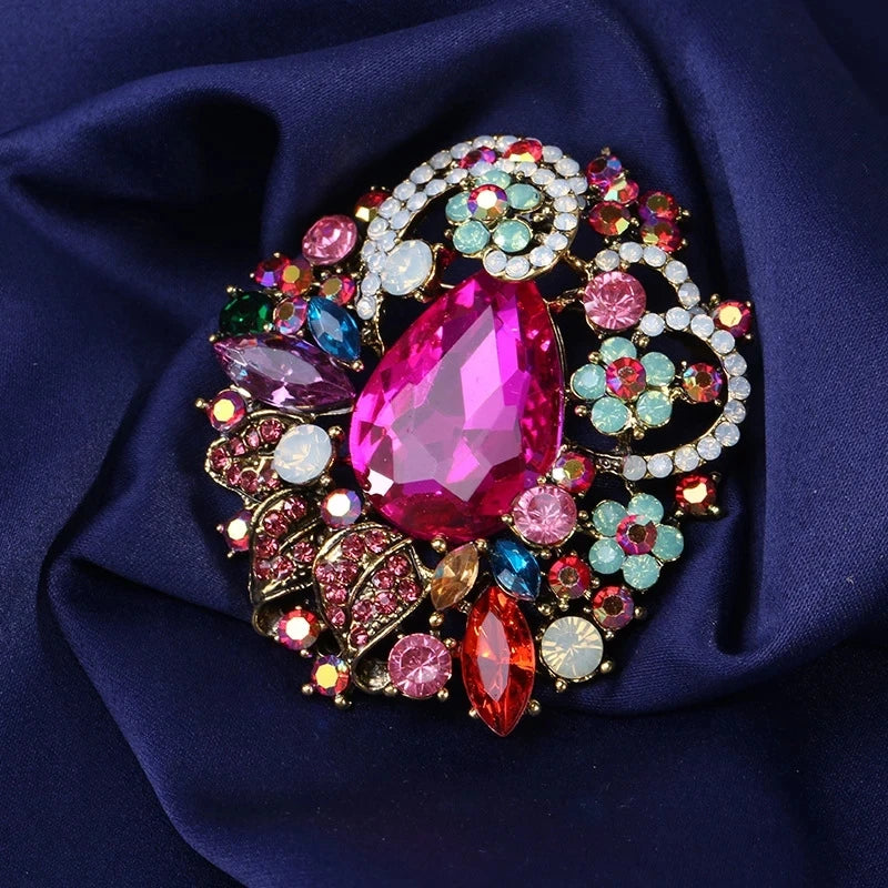 Broche florale en cristal élégante avec des gemmes roses et vertes dans un métal doré.