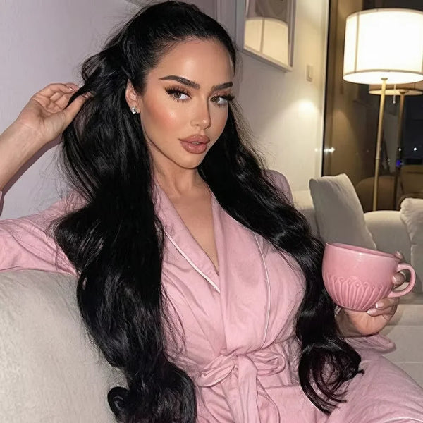 A model with long black hair wearing a pink satin robe and holding a pink mug.
