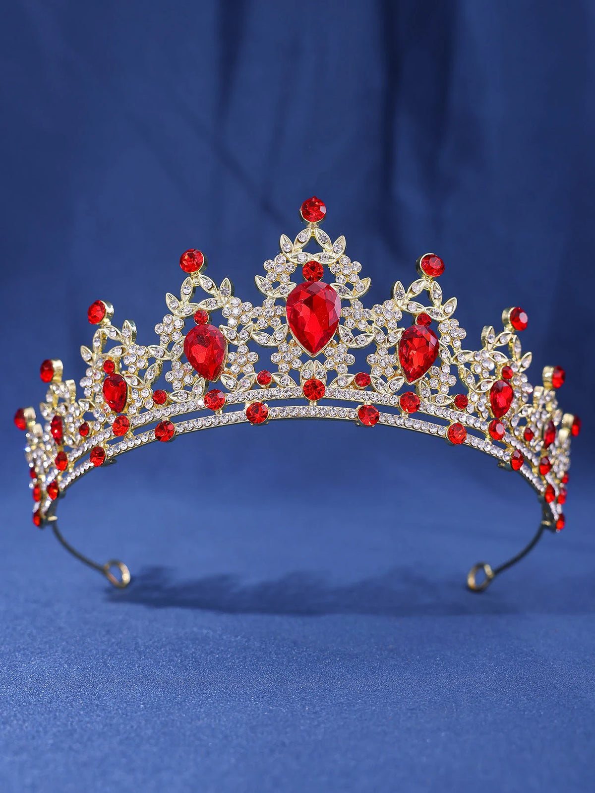 A sparkling crystal rhinestone tiara and headband set featuring red gemstones on a royal crown design.