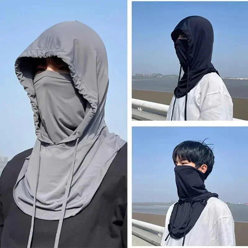 A person wearing a gray lightweight sun protection hood and face covering outdoors.