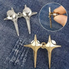 A pair of gold star-shaped decorative waist buckle buttons shown against a dark denim background.