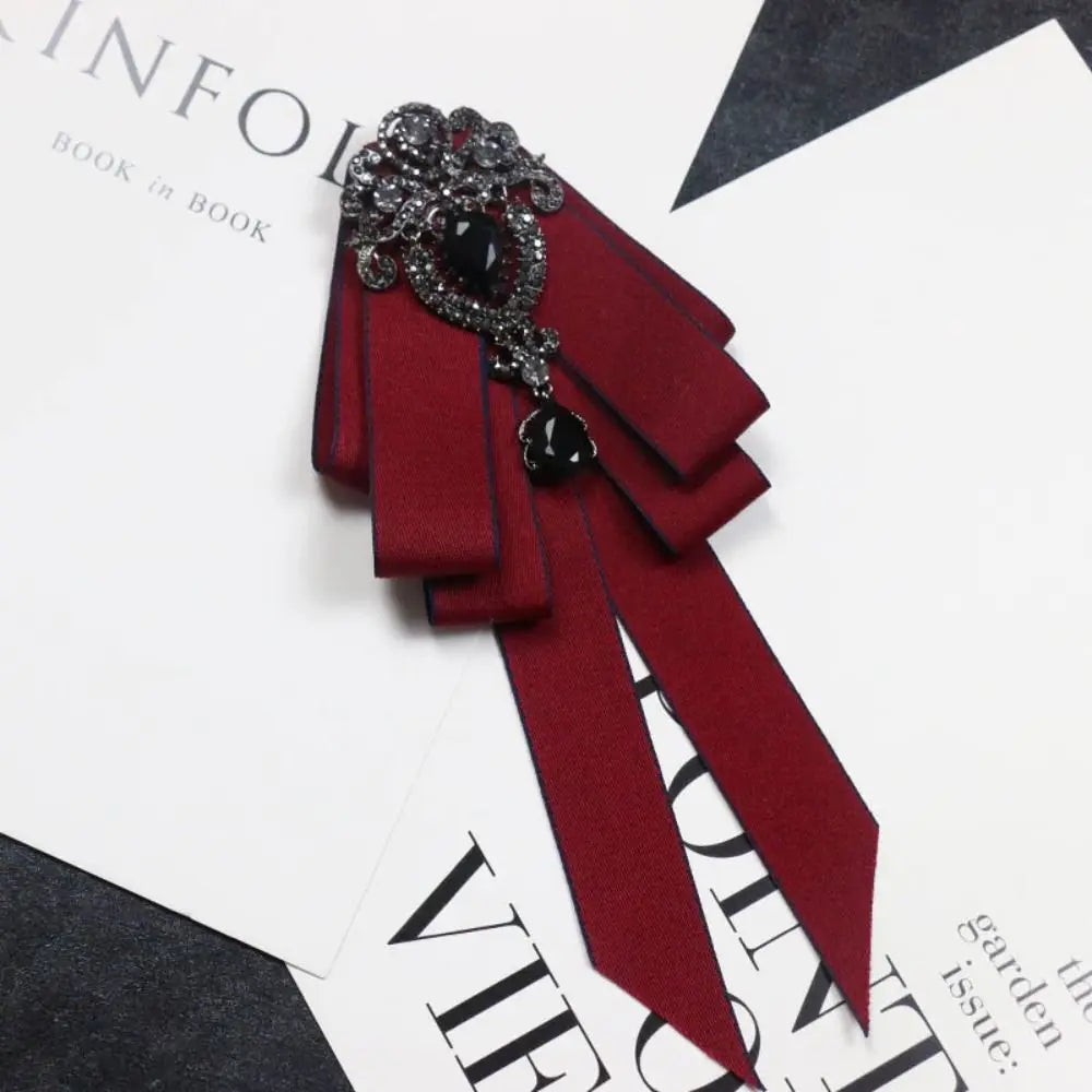 A deep burgundy velvet bow tie with black rhinestone accents shown against a white background.
