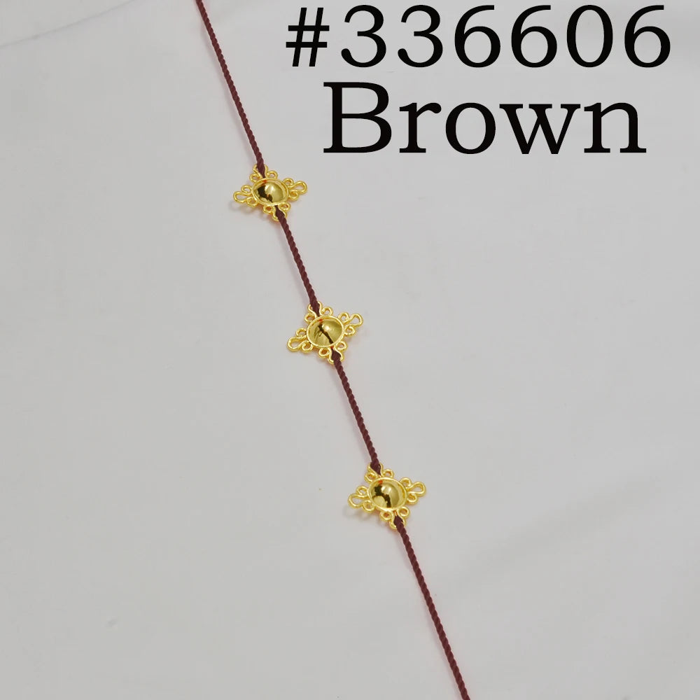 A close-up of a brown traditional Ethiopian head chain featuring gold-colored decorative elements.