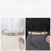 A close-up of a tan faux leather belt worn with light trousers and a black blouse.
