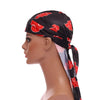 A model wearing a black bandana headwrap with red floral patterns, shown in profile.