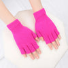 A pair of bright pink knit half finger gloves being held by hands against a white background.