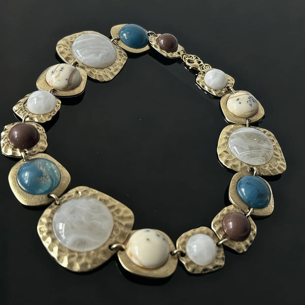 Boho-goldplattierte Resing-Statement-Halskette mit runden Perlen in blauen, weißen und braunen Tönen.