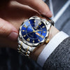 A close-up shot of a men's watch with a blue dial and gold accents being held by a hand against a dark background.