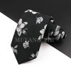 Schwarzes Luxus-Männer-Krawatte mit silbernem Blumen-Paisley-Muster, gefaltet zur Präsentation.