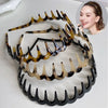 A set of black and amber fashion acetate toothed headbands displayed on a white background.