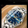 A close-up shot of a silver luxury men's quartz watch with a blue luminous dial and stainless steel bracelet.