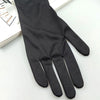 A pair of black Halloween skeleton costume gloves lying on a white surface.