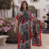 A woman models a black and red leopard zebra print maxi kaftan outdoors in a garden setting.