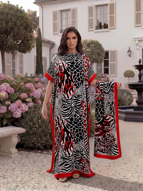 امرأة تعرض قفطان طويل بنقشة نمر zebra أسود وأحمر في حديقة خارجية.